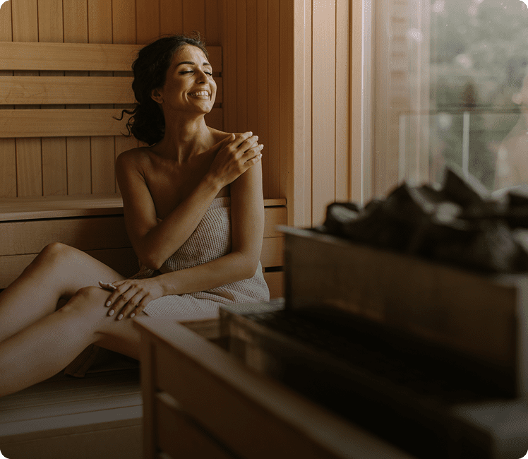 Smiling woman relaxing in a sauna.